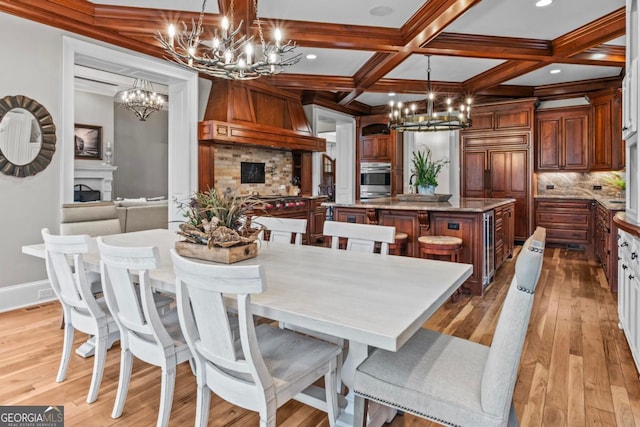 dining area with coffered ceiling, a chandelier, beam ceiling, and light hardwood / wood-style flooring