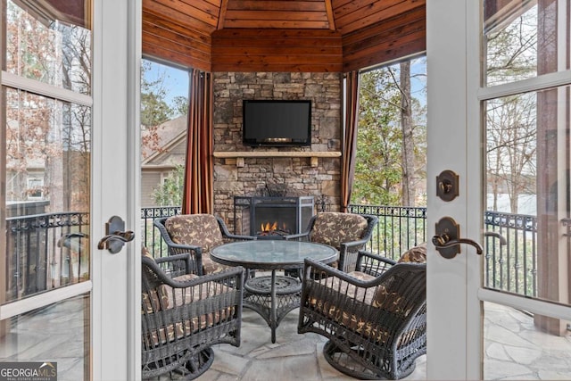 sunroom with a stone fireplace