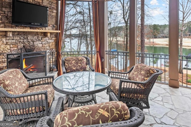 view of patio / terrace featuring a stone fireplace and a water view