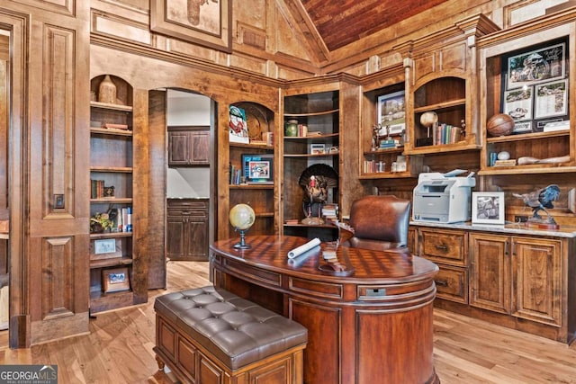 office space featuring built in features, lofted ceiling, and light hardwood / wood-style flooring