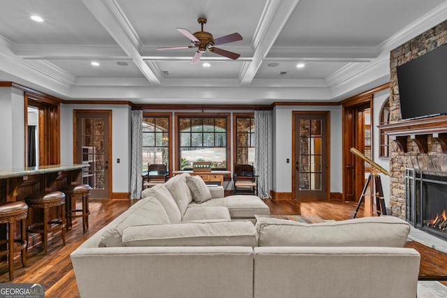 living room featuring beamed ceiling, coffered ceiling, and a fireplace