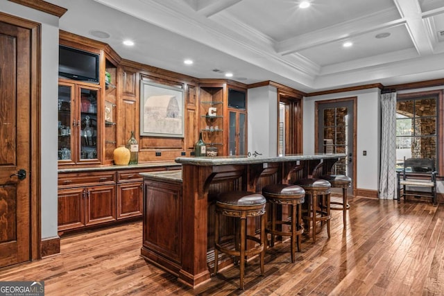 bar with crown molding, hardwood / wood-style floors, beam ceiling, coffered ceiling, and stone countertops