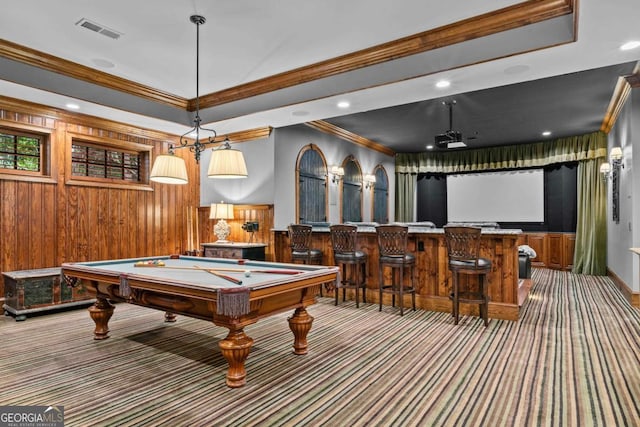 recreation room featuring bar, pool table, ornamental molding, wooden walls, and carpet