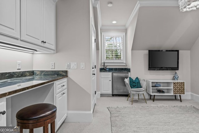 kitchen featuring crown molding, dishwasher, white cabinetry, light carpet, and dark stone counters