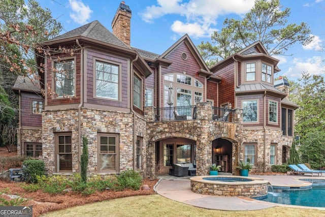 exterior space with a patio, a balcony, and a pool with hot tub