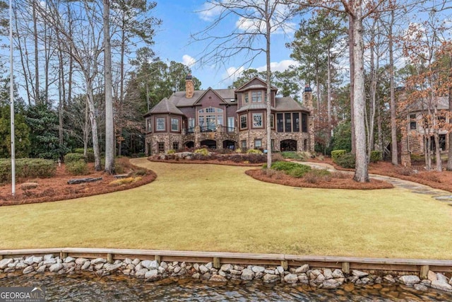 tudor home with a water view and a front yard