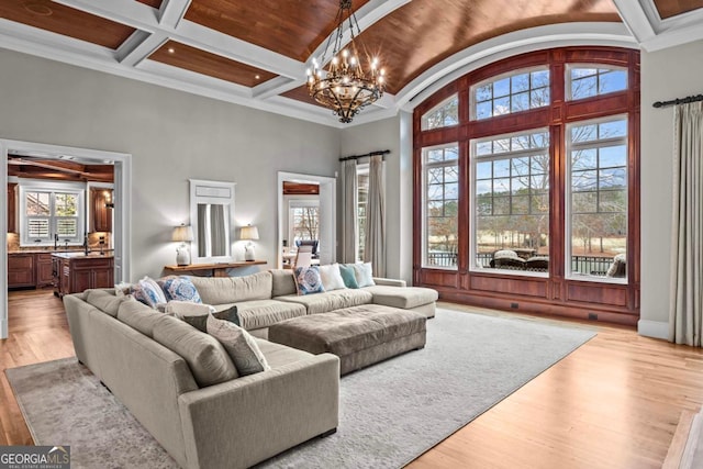 living room with high vaulted ceiling, coffered ceiling, a notable chandelier, light hardwood / wood-style floors, and beamed ceiling