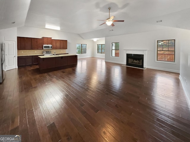 unfurnished living room featuring visible vents, baseboards, dark wood-style floors, ceiling fan, and vaulted ceiling