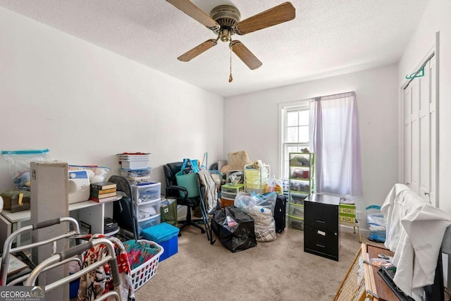 interior space featuring ceiling fan, light carpet, and a textured ceiling