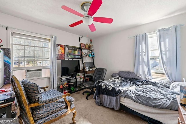 bedroom featuring multiple windows, cooling unit, a textured ceiling, and carpet