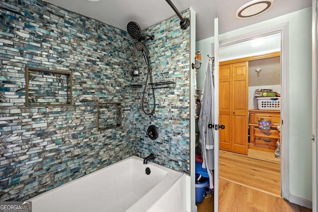 bathroom with tiled shower / bath combo and hardwood / wood-style flooring