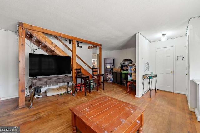 living room with wood-type flooring and a textured ceiling