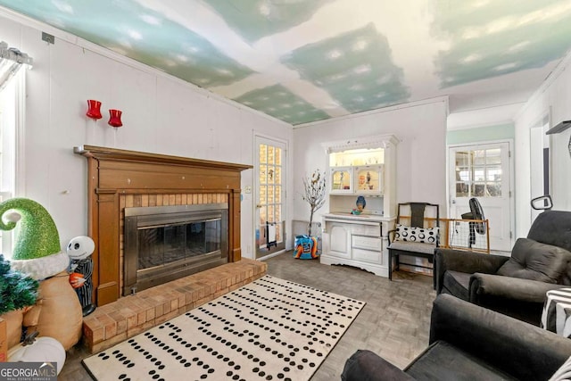 living room with crown molding and a fireplace