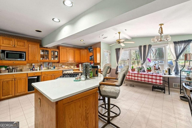 kitchen featuring pendant lighting, lofted ceiling with beams, sink, a breakfast bar area, and decorative backsplash