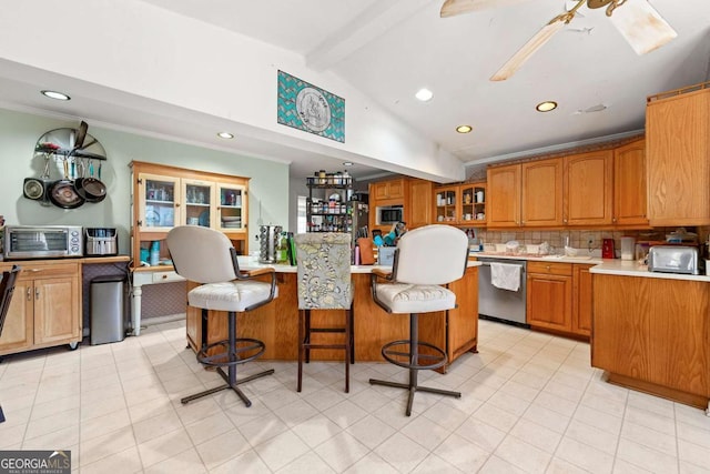 kitchen with vaulted ceiling with beams, a kitchen bar, decorative backsplash, ornamental molding, and stainless steel appliances