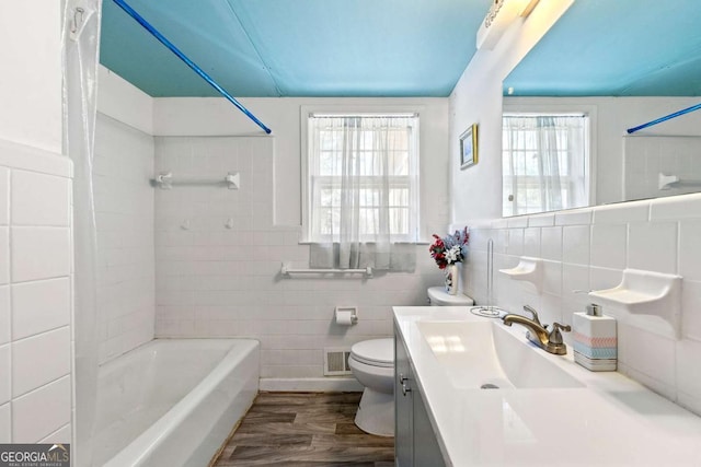 full bathroom featuring vanity, toilet, hardwood / wood-style floors, and tile walls