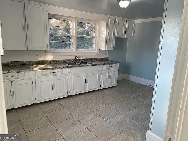 749 Grenada Ter, Macon, GA 31206 - kitchen featuring dark countertops, light tile patterned flooring, and white cabinets