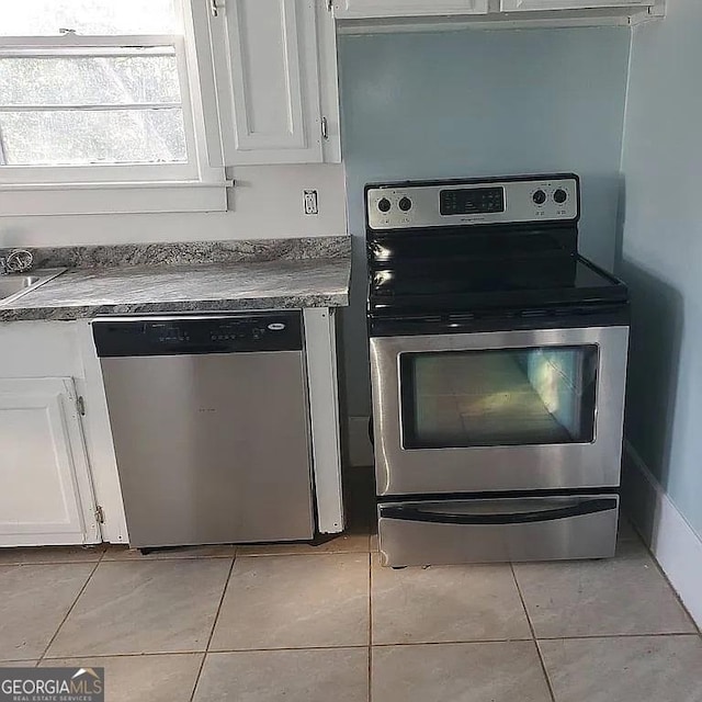 749 Grenada Ter, Macon, GA 31206 - kitchen with stainless steel appliances, light tile patterned floors, and white cabinets
