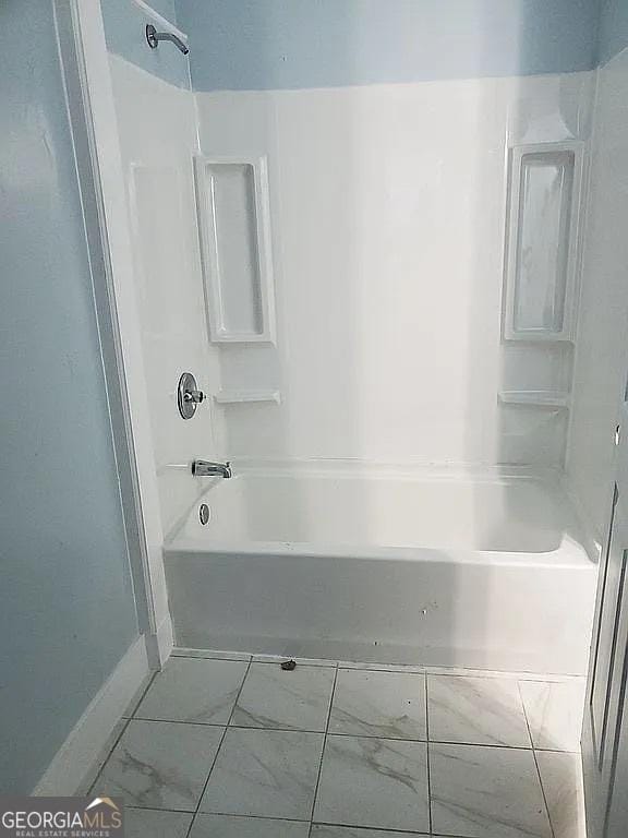749 Grenada Ter, Macon, GA 31206 - bathroom featuring shower / washtub combination and marble look tile flooring
