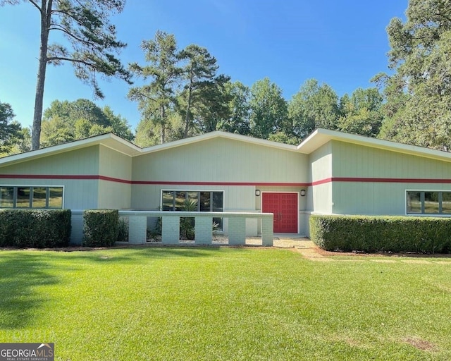 view of front of house with an attached garage and a front lawn