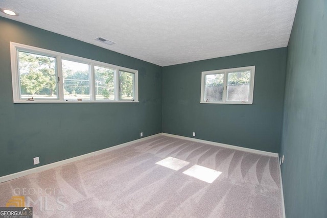 unfurnished room with plenty of natural light, baseboards, visible vents, and carpet floors