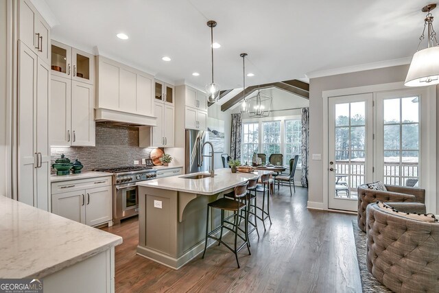 578 Brashy St, Woodstock, GA 30188 - kitchen with sink, a kitchen island with sink, white cabinetry, hanging light fixtures, and high end stainless steel range