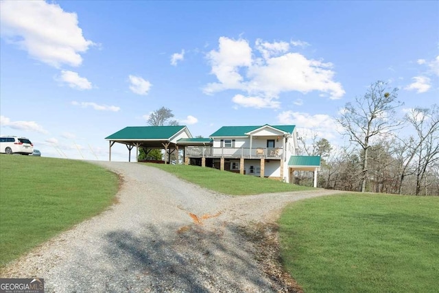 view of front facade featuring gravel driveway, a carport, and a front yard