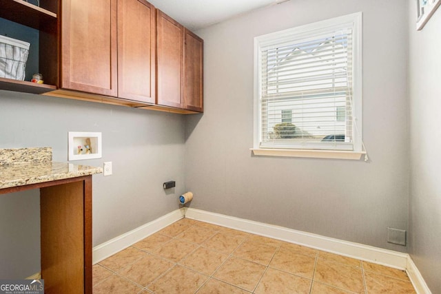 laundry area featuring cabinets, light tile patterned flooring, hookup for an electric dryer, and washer hookup