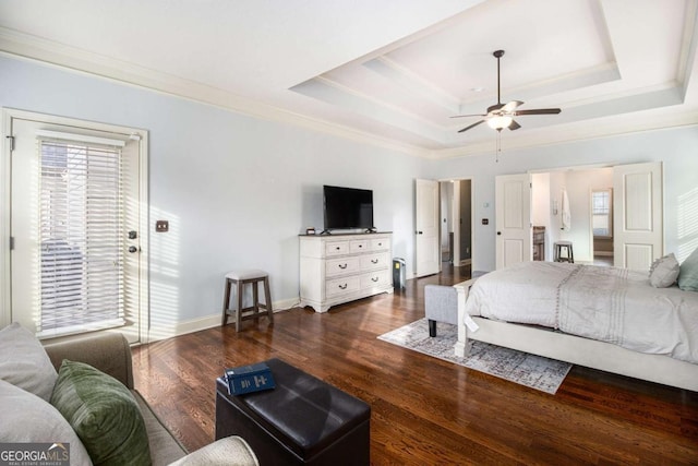 bedroom featuring crown molding, a tray ceiling, dark hardwood / wood-style flooring, and access to exterior