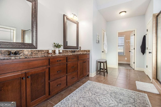 bathroom featuring a shower with door, vanity, and tile patterned floors