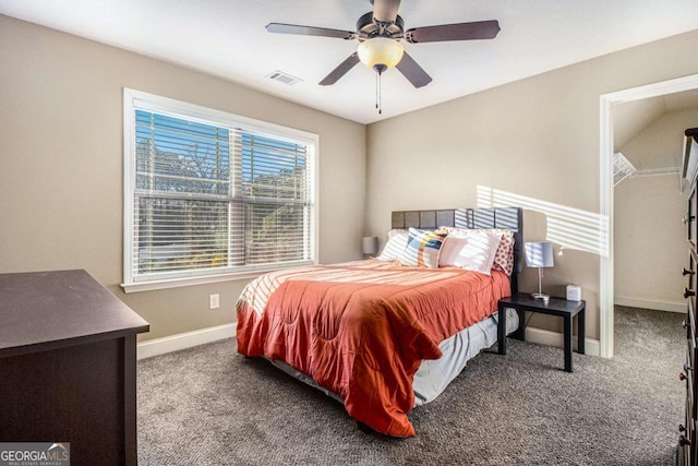 carpeted bedroom with a spacious closet and ceiling fan