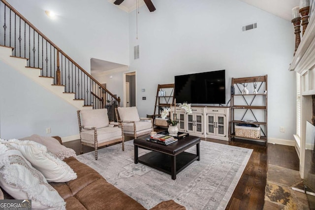 living room featuring ceiling fan, wood-type flooring, and a high ceiling