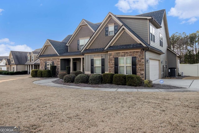 craftsman-style house featuring central AC unit and a garage