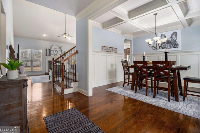 dining space with beamed ceiling, dark wood-type flooring, and ceiling fan with notable chandelier