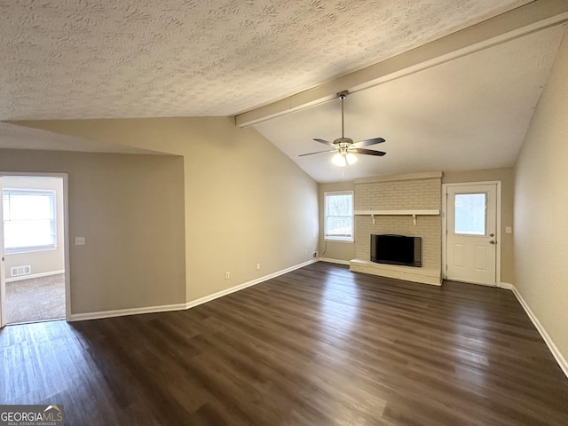 unfurnished living room with lofted ceiling with beams, a textured ceiling, dark hardwood / wood-style floors, ceiling fan, and a fireplace