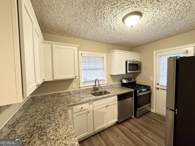 2922 Dale Pl, Decatur, GA 30032 - kitchen with sink, white cabinetry, stainless steel appliances, dark hardwood / wood-style floors, and light stone counters