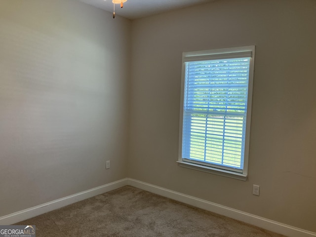 carpeted spare room featuring ceiling fan