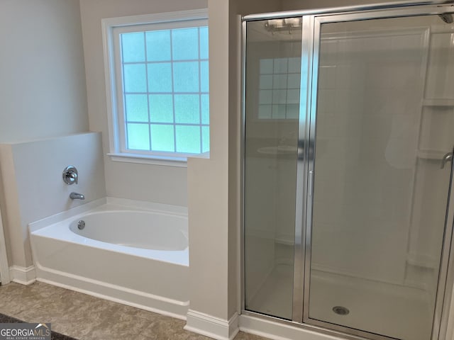 bathroom featuring shower with separate bathtub