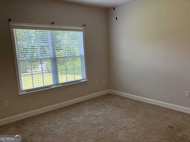 carpeted spare room featuring plenty of natural light