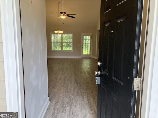 foyer entrance with high vaulted ceiling, ceiling fan with notable chandelier, and light hardwood / wood-style flooring