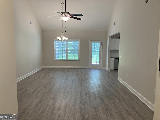 unfurnished living room with high vaulted ceiling, ceiling fan with notable chandelier, and dark hardwood / wood-style flooring