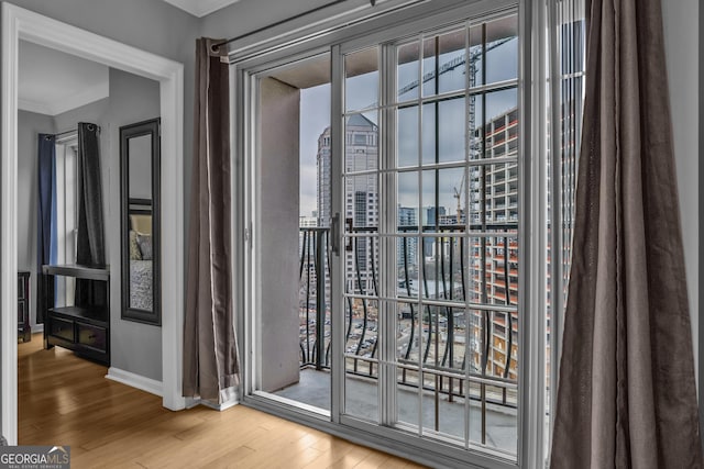 doorway to outside featuring crown molding and hardwood / wood-style flooring