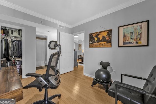 workout area with ornamental molding, light wood-type flooring, visible vents, and baseboards