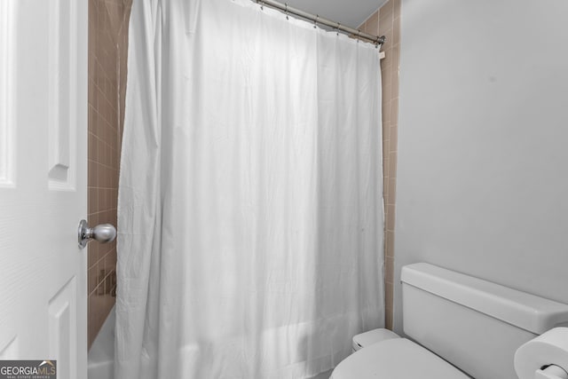 bathroom featuring shower / bath combination with curtain and toilet