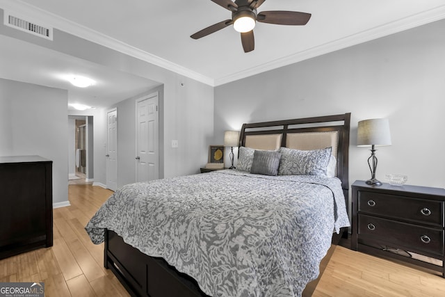 bedroom with ceiling fan, visible vents, baseboards, light wood-style floors, and ornamental molding