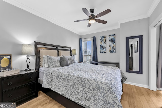 bedroom with ornamental molding, light wood finished floors, and baseboards