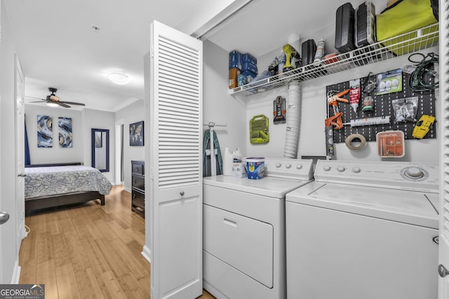 laundry area featuring crown molding, light wood-style floors, a ceiling fan, laundry area, and independent washer and dryer