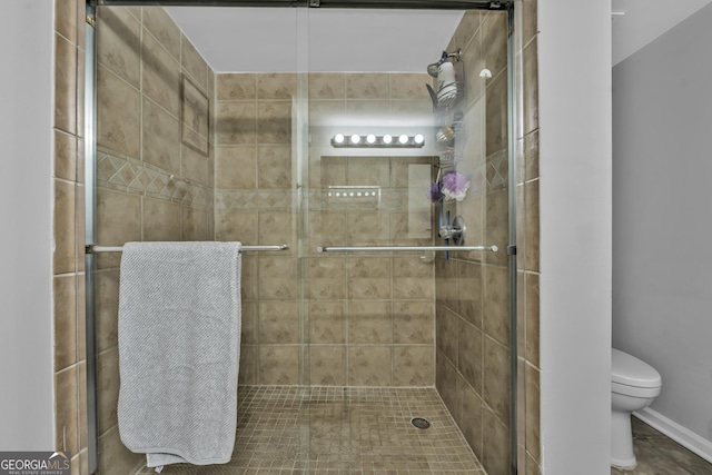 full bath featuring a stall shower and toilet