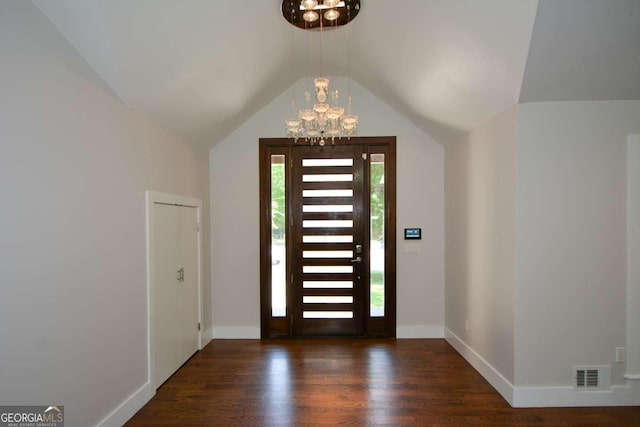 foyer entrance featuring lofted ceiling, dark hardwood / wood-style floors, and an inviting chandelier