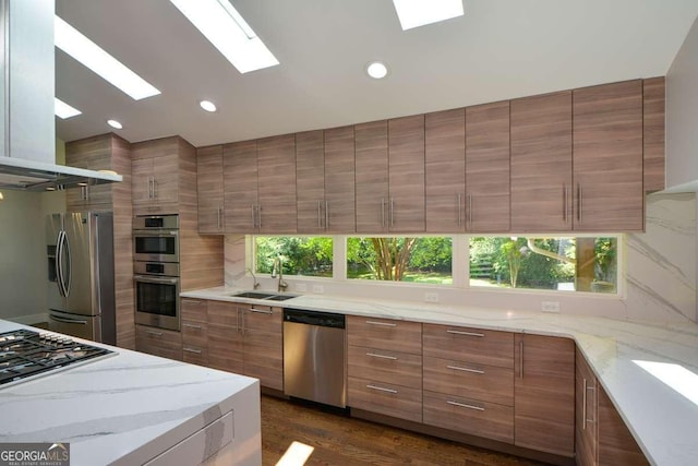 kitchen featuring stainless steel appliances, plenty of natural light, sink, and island range hood